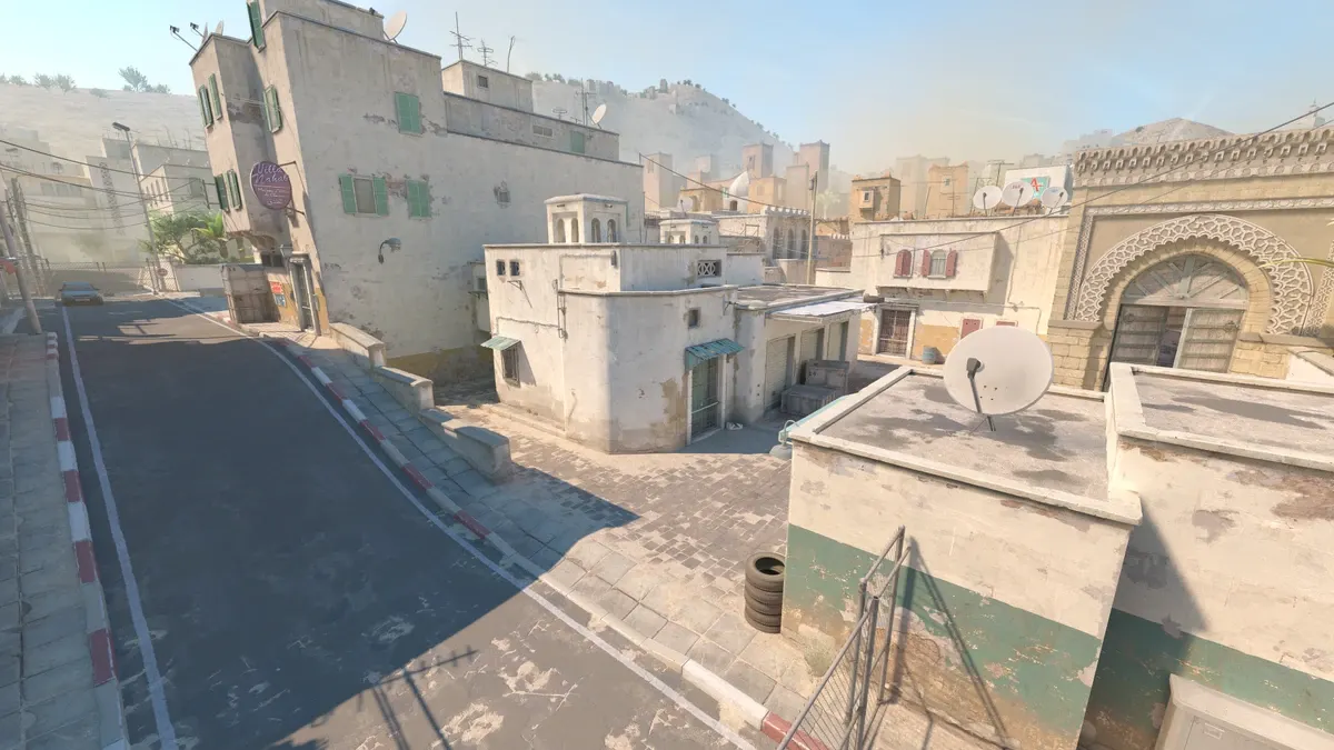 Urban scene with bustling street, tyres, and buildings, showcasing the CS2 map Dust 2.